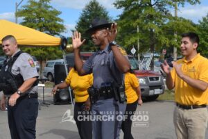 An officer throws his hands up in the air during the electric slide contest.
